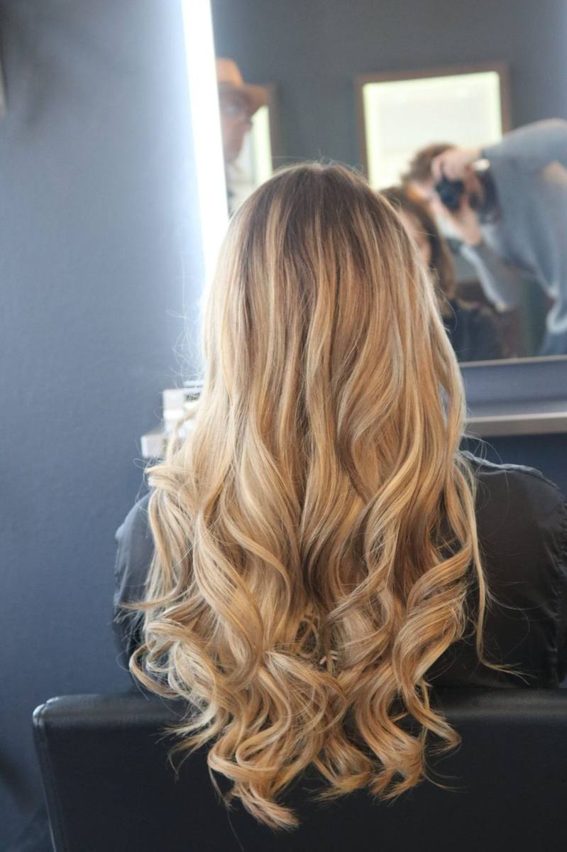 Long blonde balayage hair finished in soft, loose waves